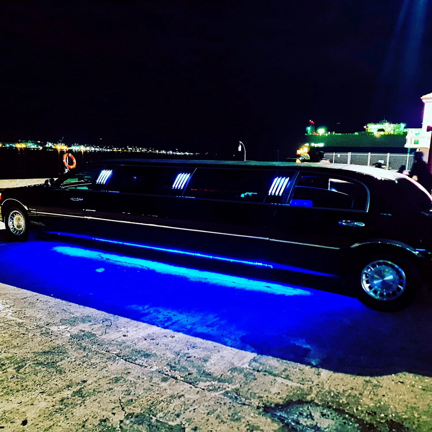 Black Lincoln stretch limo with blue LED underglow on the Auckland waterfront at night